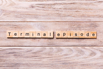 terminal episode word written on wood block. terminal episode text on wooden table for your desing, coronavirus concept top view