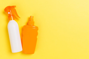 flat lay concept of summer travel vacation. Sunscreen bottle mock up on yellow background top view with copy space