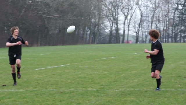 Rugby Match. Players pass the ball to their team on the rugby field. Slow motion