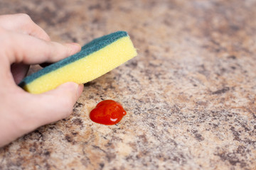 hand wipes the stain with a sponge
