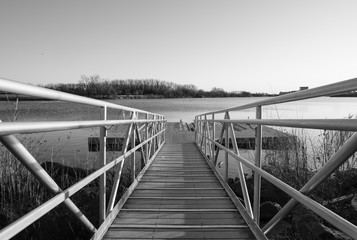 Fototapeta premium Walkway ramp to lake boat dock. Steel ramp walkway leading to boat landing.