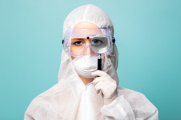 medic woman wearing protective clothing against the virus with magnifying glass