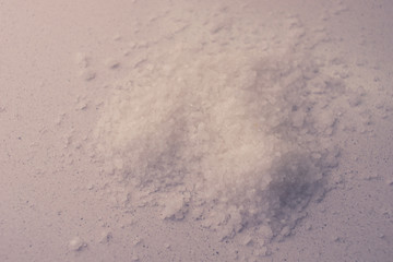 White sea salt on the table, pile closeup, top view.