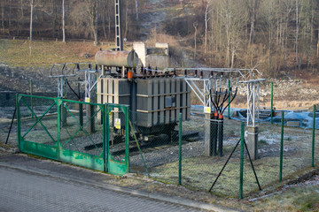 Fototapeta na wymiar Small high voltage transformer at the hydroelectric power plant