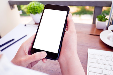  Mockup picture of business woman’s hands holding smart phone with white blank screen in modern place.