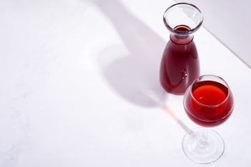 red wine in a wineglass with shadows isolated on stone background
