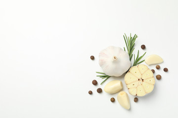 Garlic bulbs, slices, spice, parsley, rosemary on white background, top view. Space for text