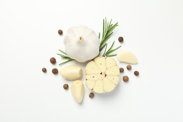 Garlic bulbs, slices, spice, parsley, rosemary on white background, top view. Space for text