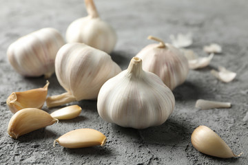 Garlic bulbs, slices on grey background, closeup