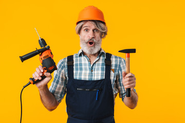 Shocked man builder holding drill.