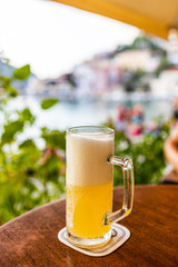 Glass of beer on a table near the beach