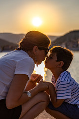 Mother and son looking each other at sunset