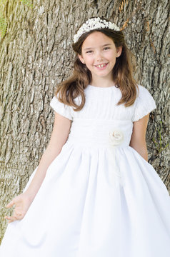 Cute girl smile wearing the white dress of her first holy communion