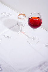 red wine in a wineglass with shadows isolated on white textile background