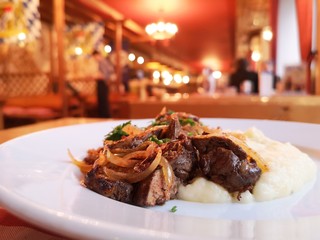Roasted liver with onions and mashed potatoes in a restaurant.