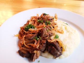Roasted liver with onions and mashed potatoes in a restaurant.