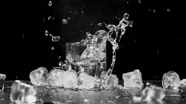 Ice dropped into glass in super slow motion. Shot with cinema camera RED DRAGON, 240fps. Close Up Slow Motion Black and White Shot, Isolated Background