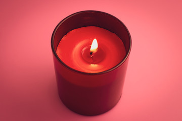 Obraz na płótnie Canvas Red candle with flame on pink background. Aromatherapy, relaxation concept.
