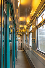 The aisle in riding wagon. The interior of moving train with empty corridor.