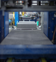 Insulation panels are running through a calibrating machine
