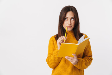 Image of beautiful brunette adult woman making notes in diary book