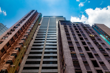 Fototapeta premium View of multistory residential complex with apartments in metropolis center of Hong Kong. Perspective view from the bottom up