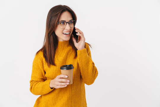 Image of adult woman holding coffee cup and talking on cellphone