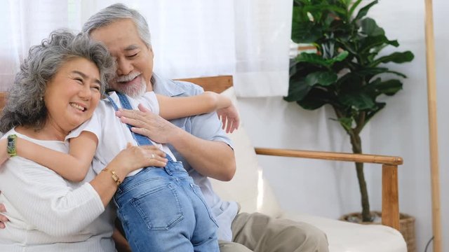 Girl go to hug grandparent sit on sofa in living room with concept happy family.