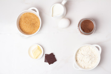 dessert baking ingredients: flour, cocoa, butter, milk and eggs and place for text