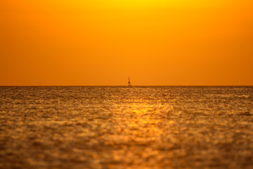 Sea buoy in the ocean on a sunset background
