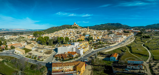 Aerial view of Biar castle in Valencia province Spain with donjon towering over the town and concentric walls reinforced with semi circular towers on a sunny day with blue sky