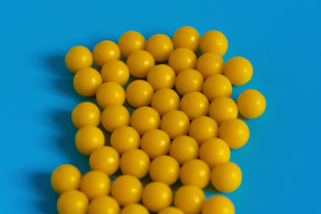 Yellow vitamins on a blue background. Vitamin complex against the virus. Multivitamins to enhance health and immunity. Medical concept