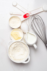 organic products milk, flour, eggs and butter on a white background top view