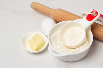 flour, rolling pin and eggs on a white background