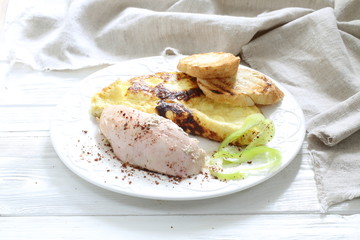 Baked chicken breast with spices and scrambled eggs with croutons