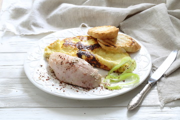 Baked chicken breast with spices and scrambled eggs with croutons