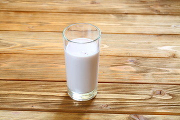 Yogurt in a transparent glass on a wooden table