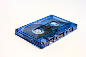 Audio cassette shot isolated on white background. Black and blue plastic magnetic audio tape.