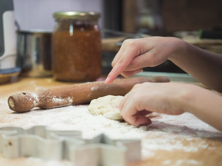 Child makes dough. Close up of hands child that make dough with rolling pin and cookies shapes