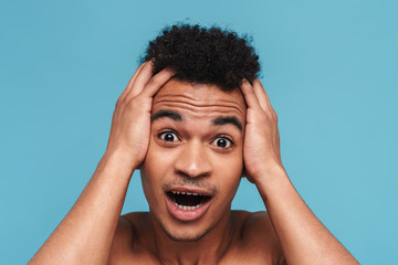 Photo of shocked african american man grabbing his head