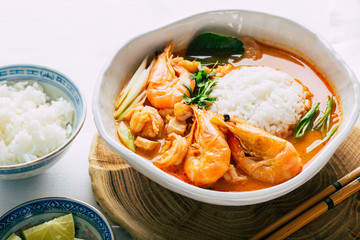 Tasty Tom Yam with shrimp and rice, spicy Thai soup, close-up