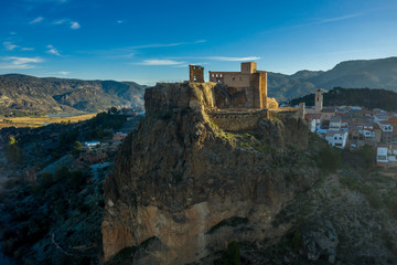 Aerial panoramic view of medieval partially restored Cofrentes castle above the Cabriel river in...