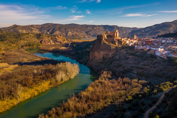 Fototapeta na wymiar Aerial panoramic view of medieval partially restored Cofrentes castle above the Cabriel river in Spain with reflection
