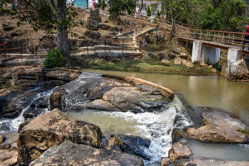 Small water reservoir in stone mountain with bridge for communication from one side to another.