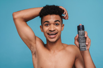 Photo of excited african american man showing his armpit and deodorant