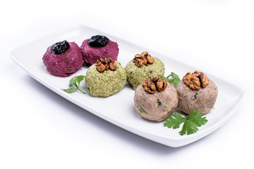 pkhali with nuts on a white plate