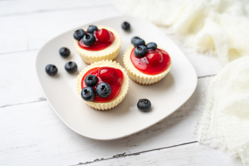 Mini cheesecakes with cherry and blueberry topping, sweet summer treat