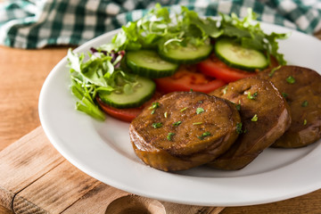 Seitan with vegetables on wooden table. Fake meat