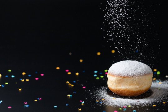 German Doughnut with confetti infront of a black background
