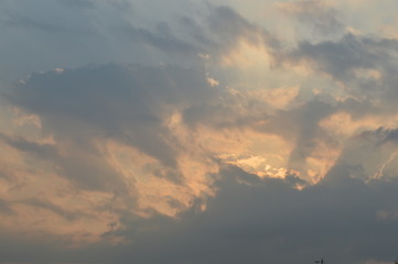 The light of the rising sun in the morning surrounded by clouds.